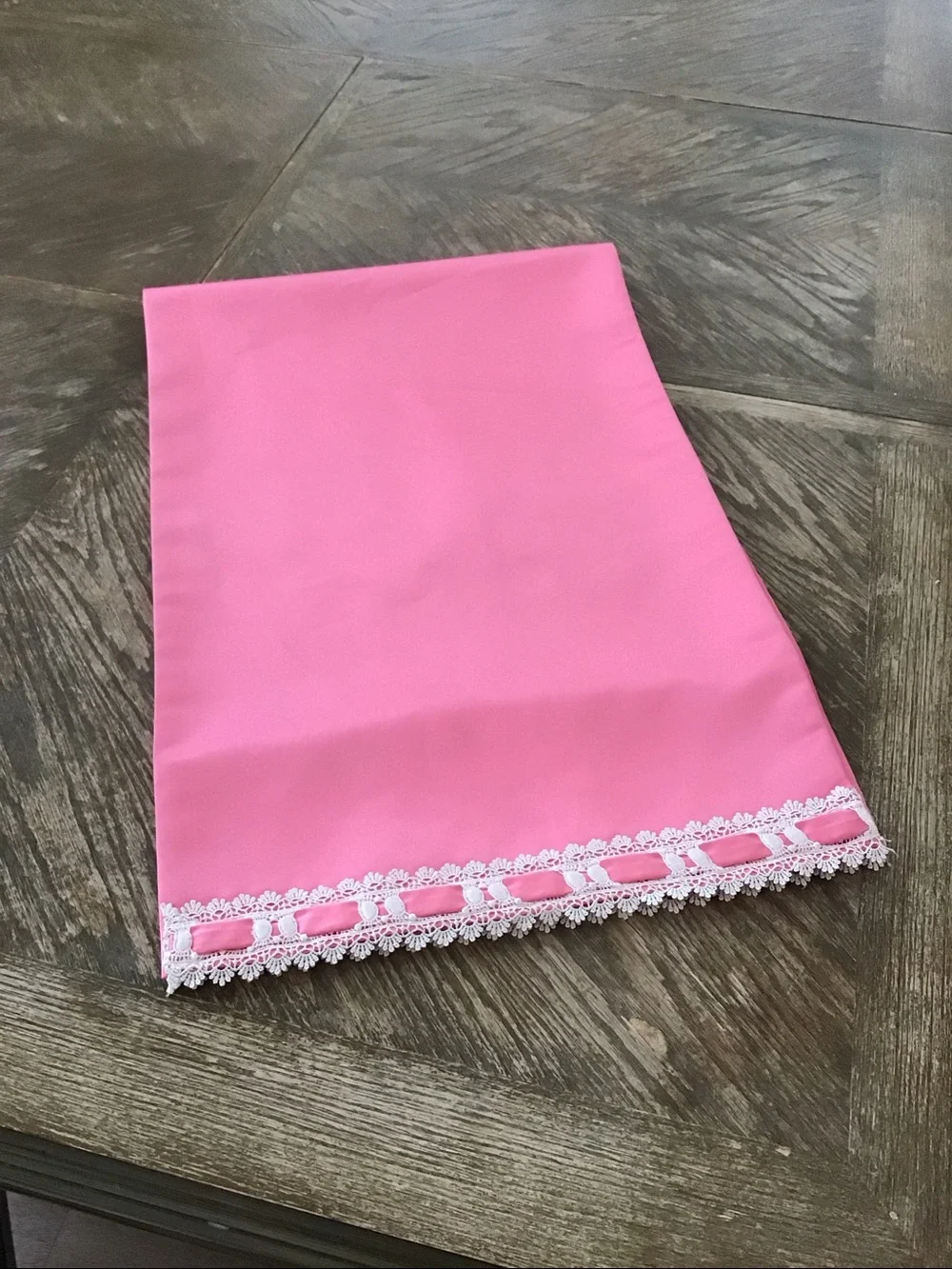 Table runner features a decorative white lace and ribbon trim